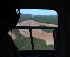 Imagem de dentro do helicoptero para fora, focado na área desmatada
