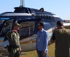 equipe PM e IAT próximos ao helicoptero pousado no chão