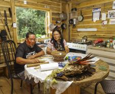 Foto de casal indígena sentado à mesa