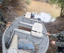 Fiscais manejando um bote no acampamento de caçadores