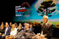 Apresentação fórum Paranaense de Mudanças Climáticas com membros assentados e apresentador discursando