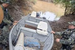 Fiscais manejando um bote no acampamento de caçadores